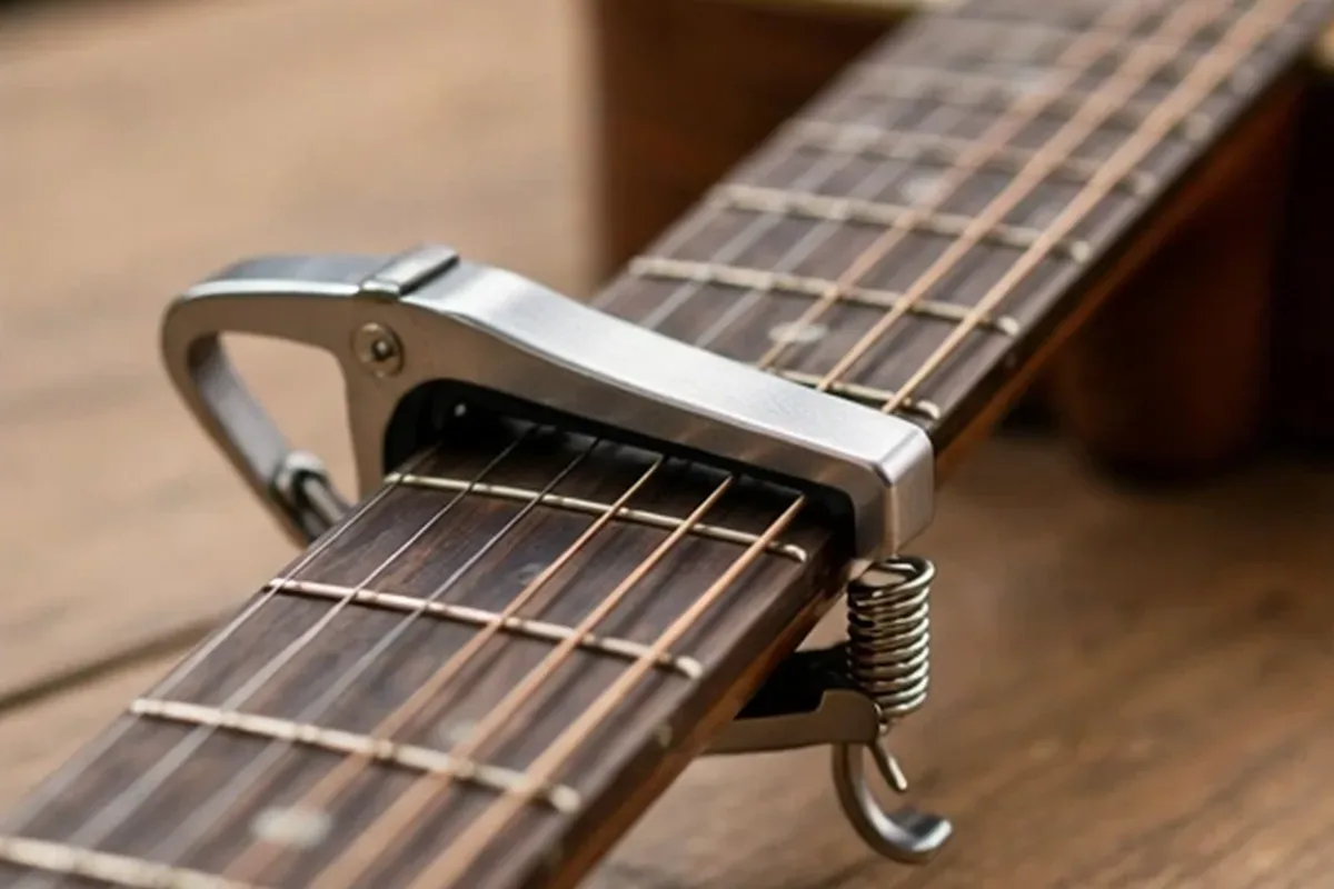 Capo clamped on an acoustic guitar fretboard
