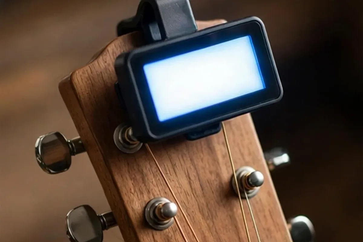 Clip on tuner attached to an acoustic guitar headstock